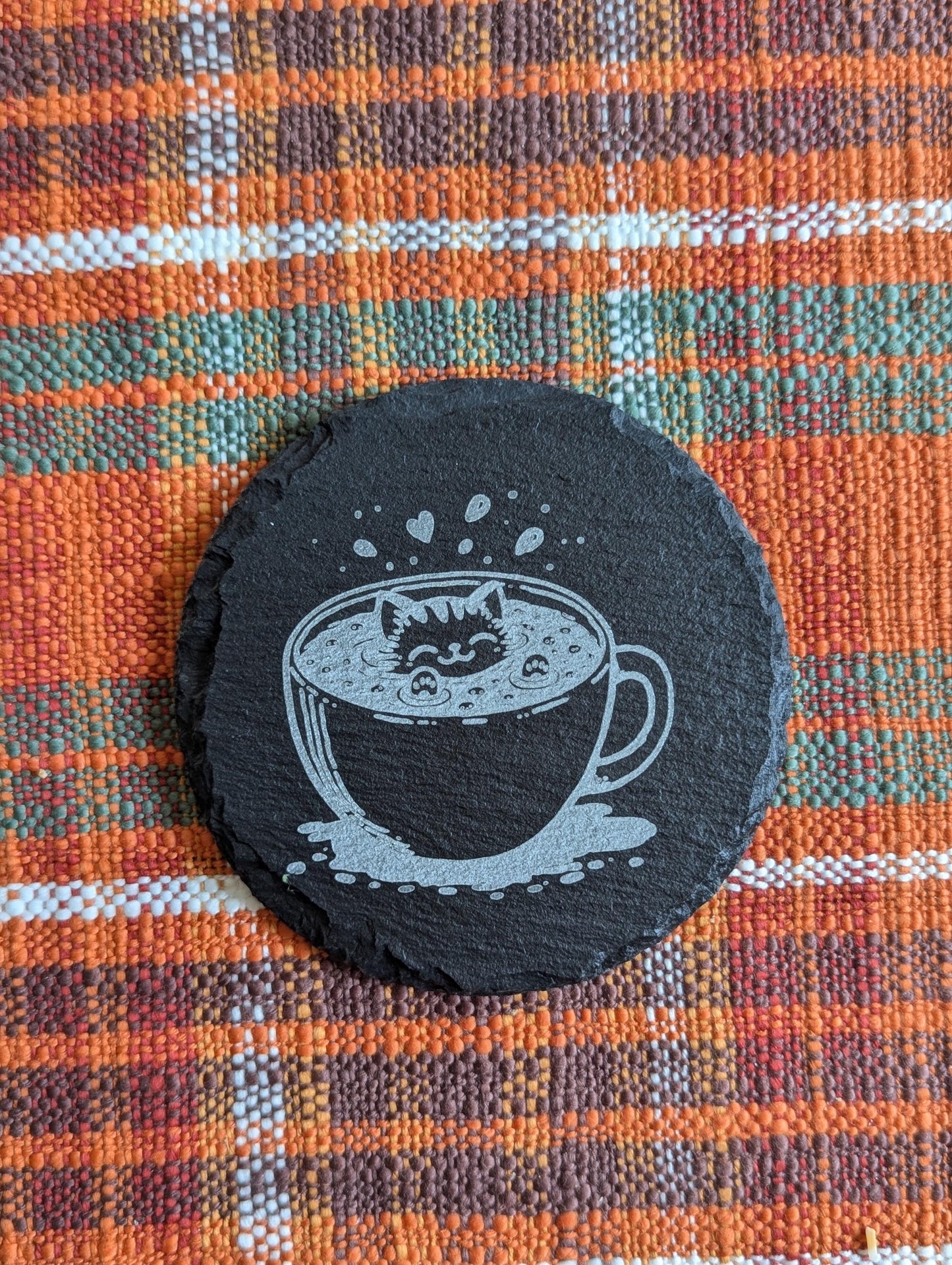 Slate coaster with a laser-engraved design of a cute cat swimming in coffee.