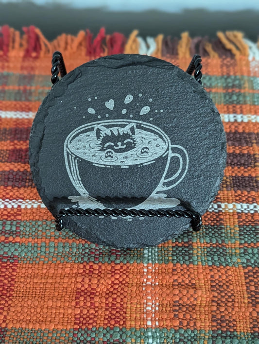 Slate coaster with a laser-engraved design of a cute cat swimming in coffee.