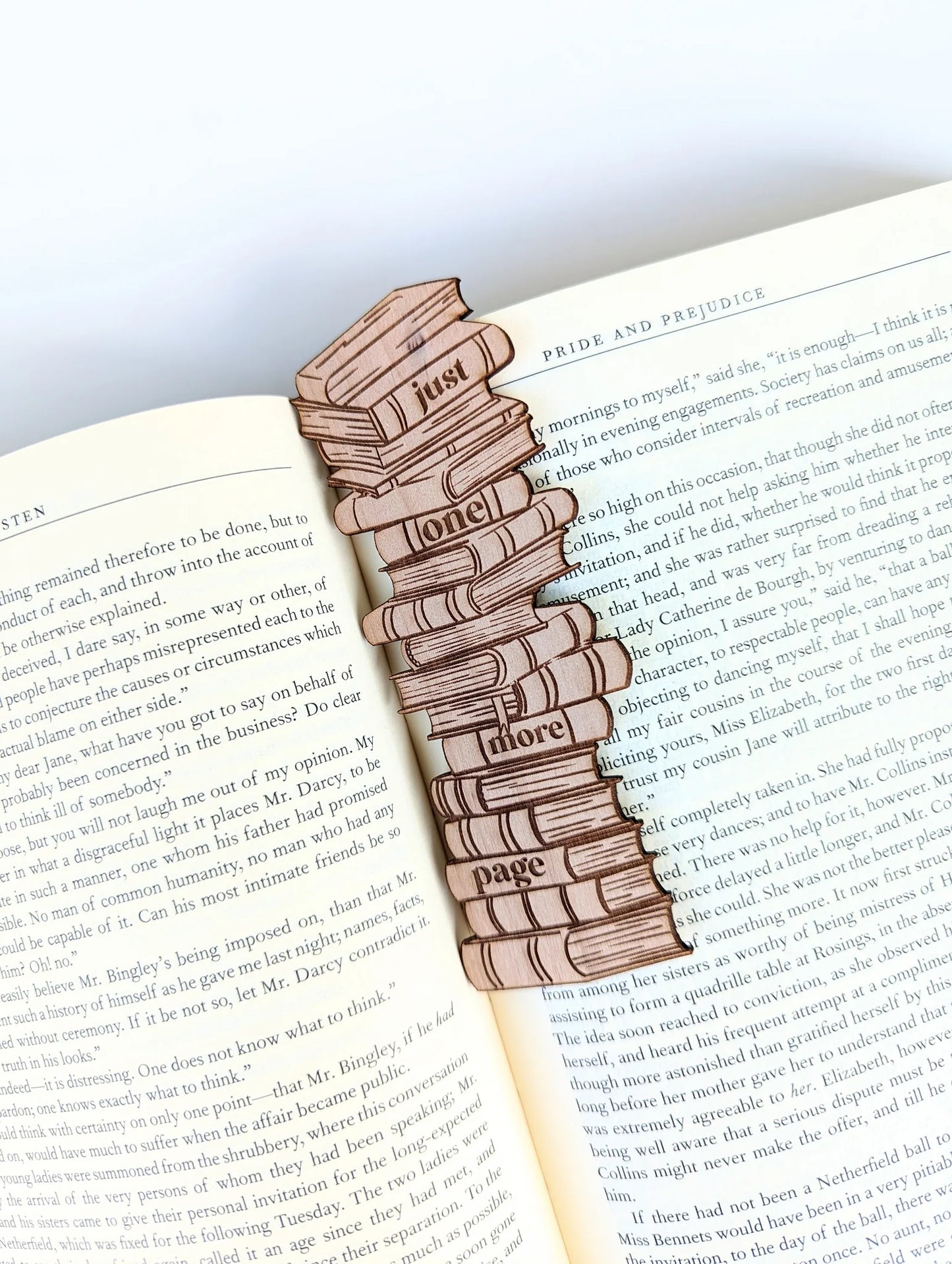 A wooden bookmark that says "Just one more page."