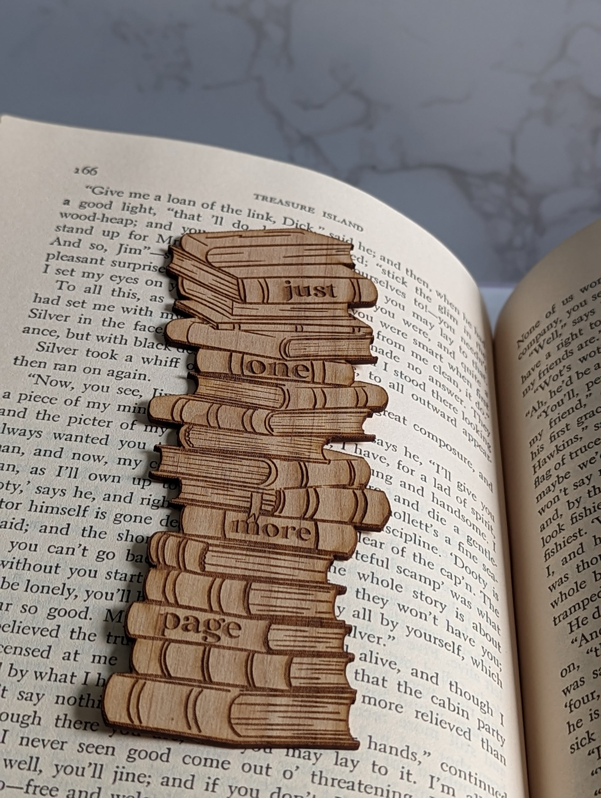 A wooden bookmark that says "Just one more page."