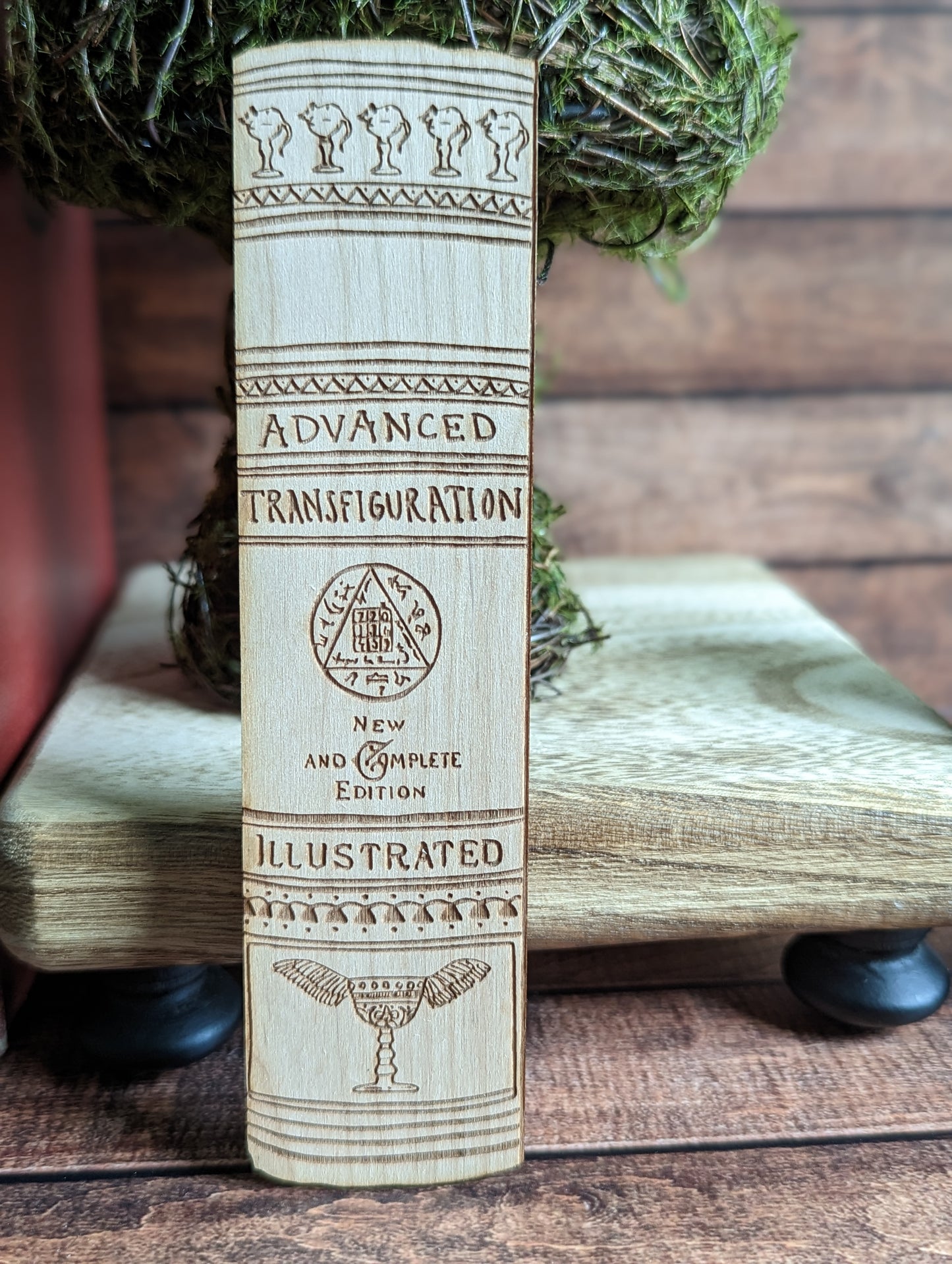 A wooden bookmark that says "Advanced Transfiguration. New and Complete Edition. Illustrated."