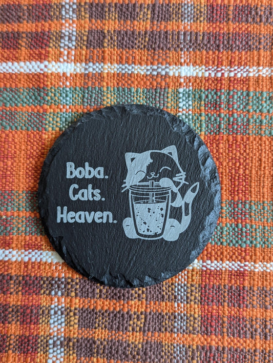 Slate coaster with a laser-engraved design of a cute cat sipping boba alongside text that says boba, cats, heaven.