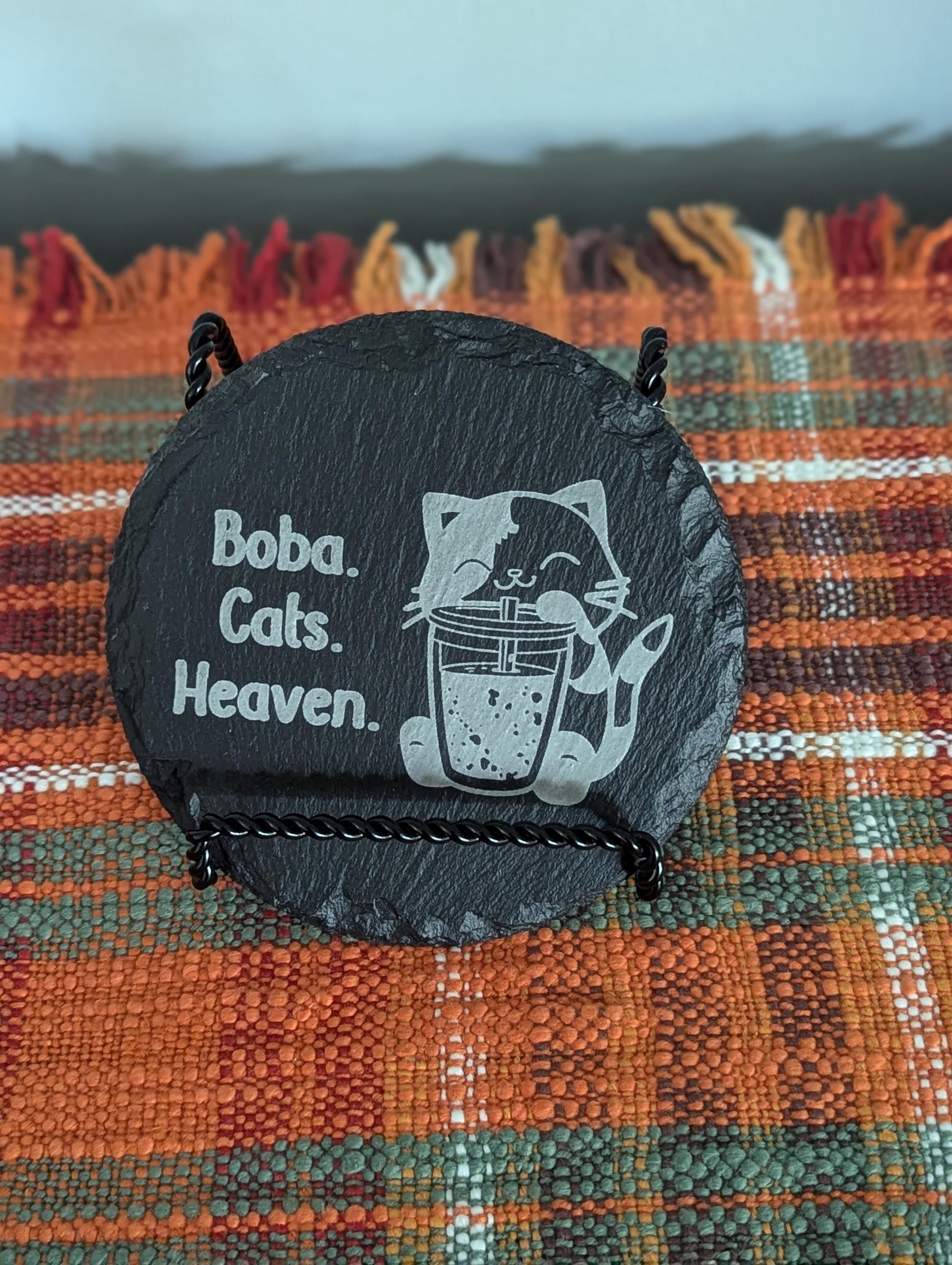 Slate coaster with a laser-engraved design of a cute cat sipping boba alongside text that says boba, cats, heaven.