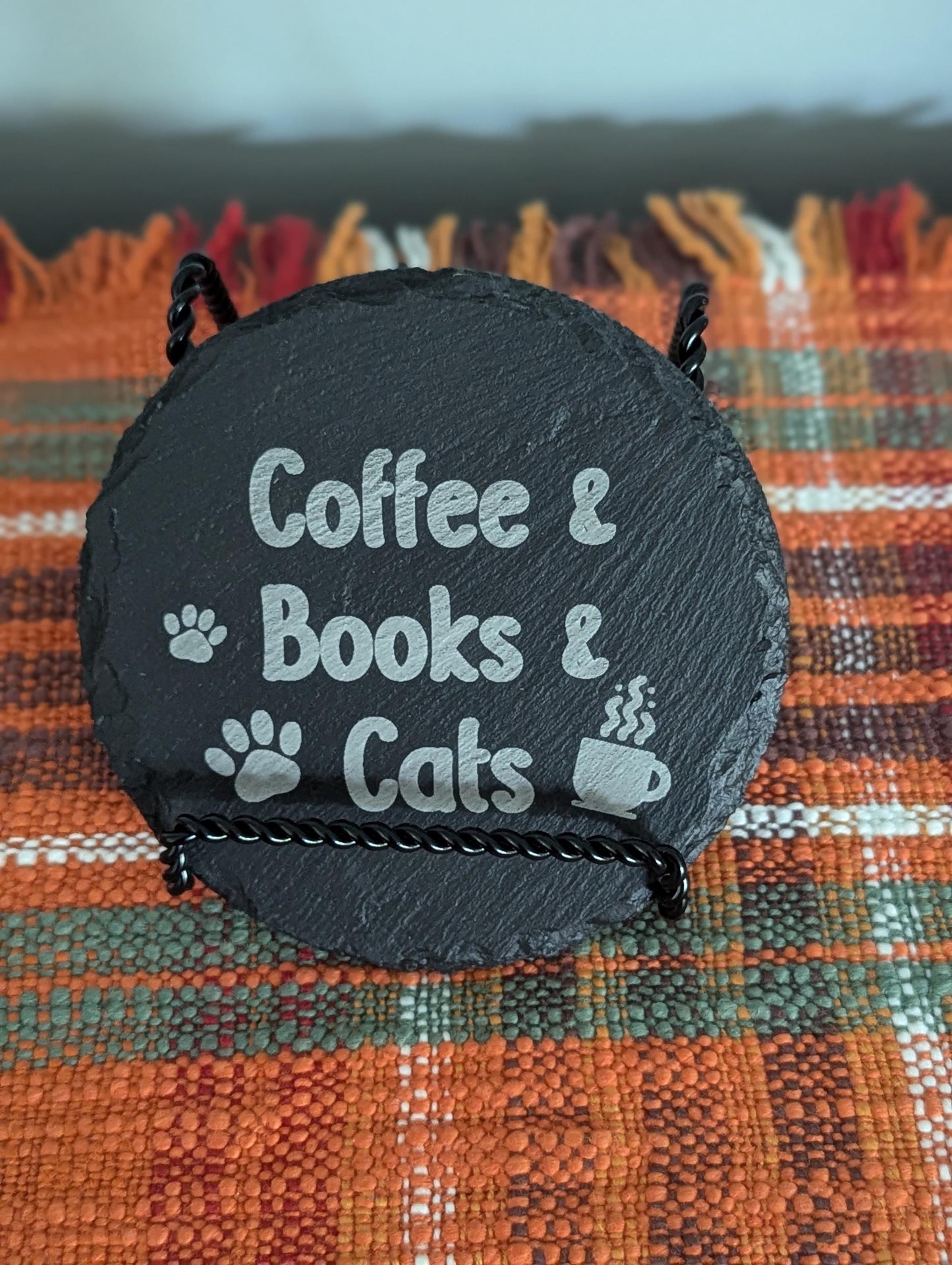 Slate coaster laser-engraved with text that says Coffee & Books & Cats; with some paw prints and a steaming coffee cup.