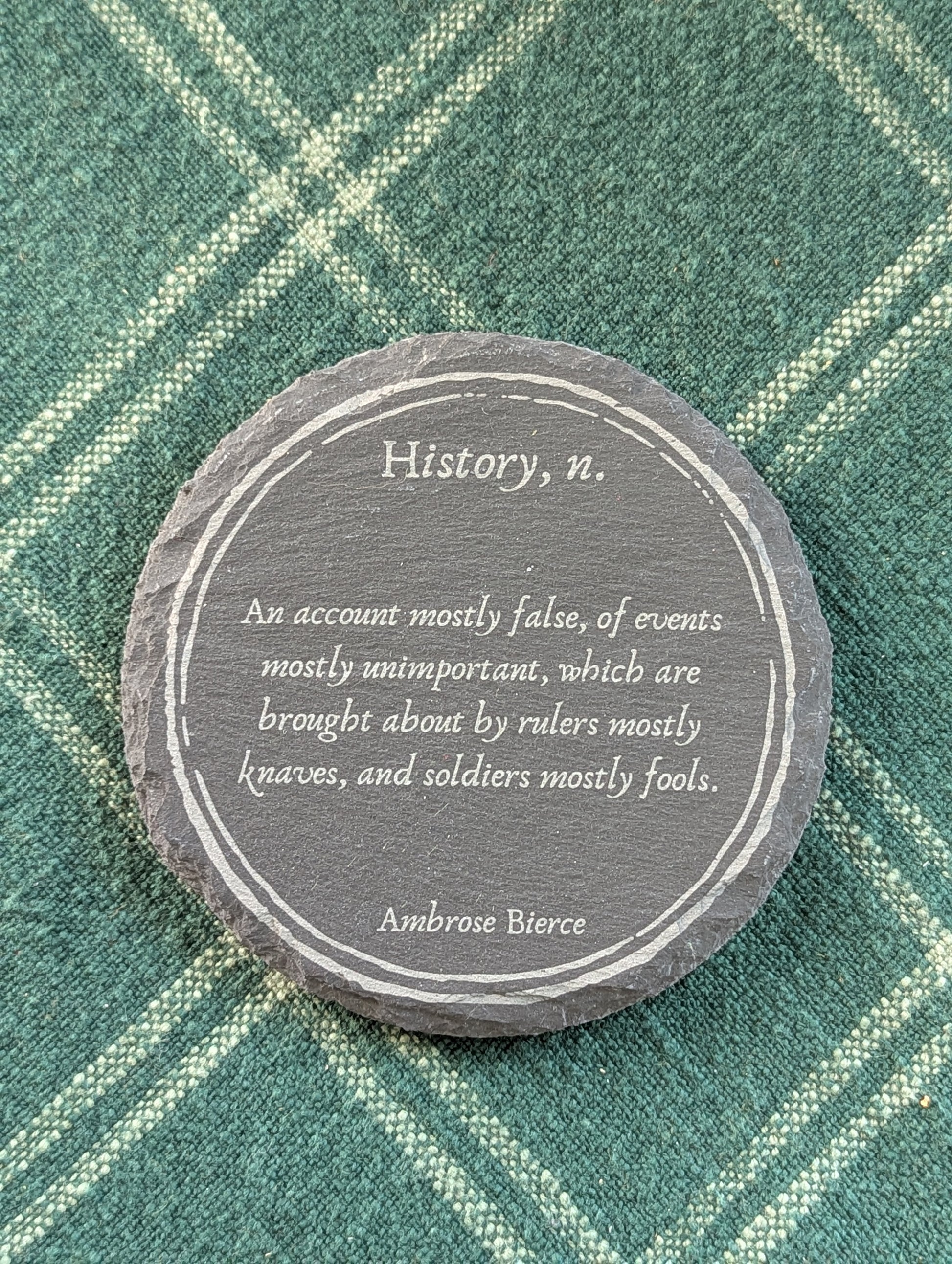 Slate coaster with a laser-engraved design of a definition of history by Ambrose Bierce.