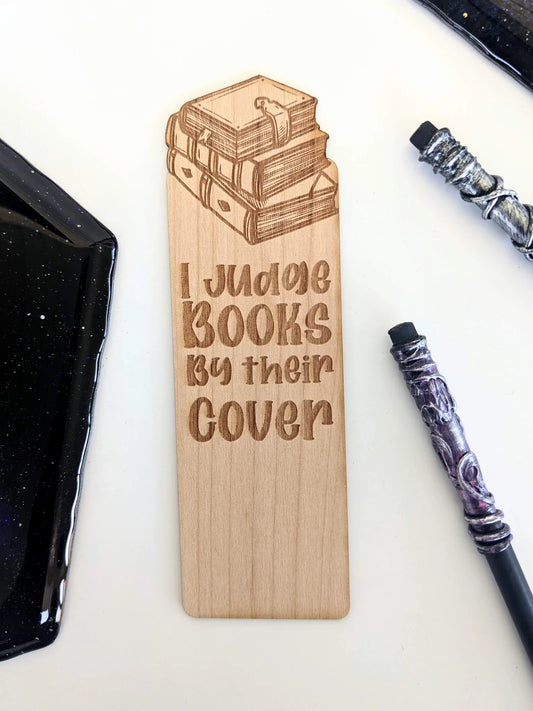 Wooden bookmark that says "I judge books by their cover."